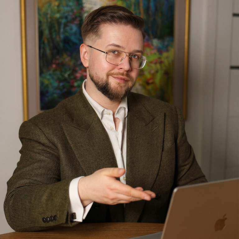 Damian Dawid Nowak z laptopem przy biurku, zapraszający do zapoznania się z naszą ofertą usług i współpracy.